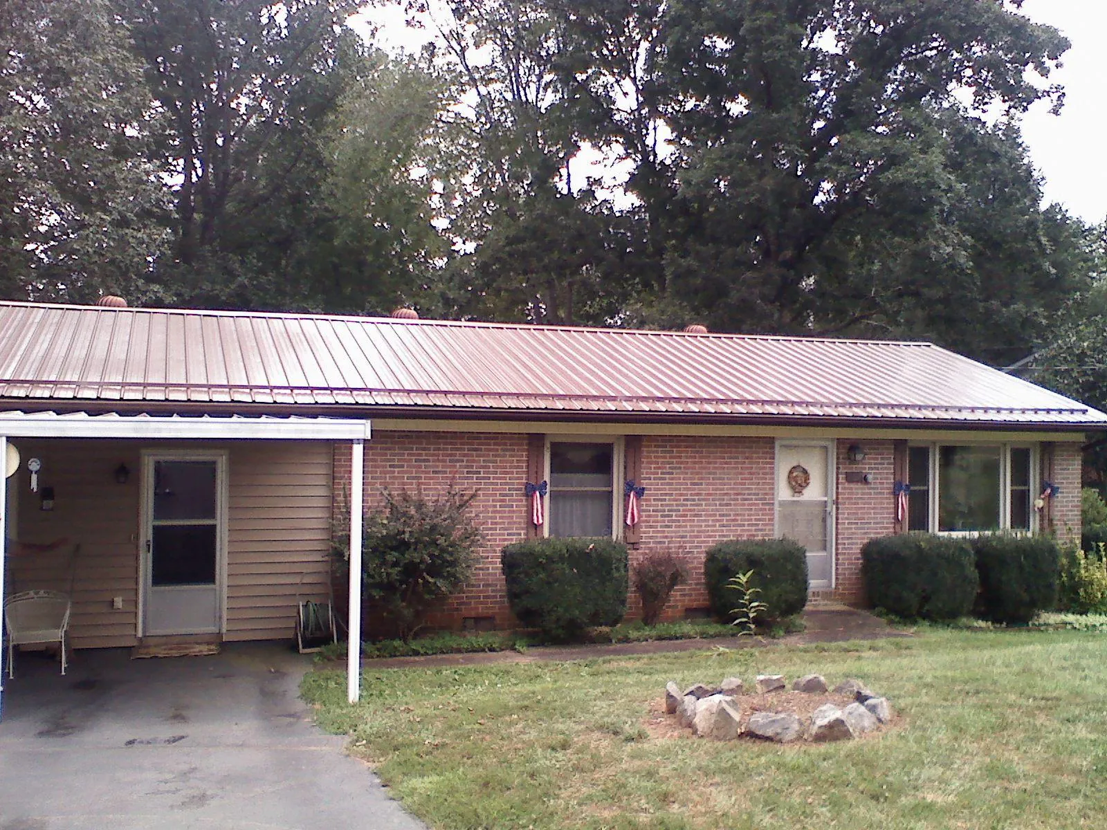 Bronze metal roof and carport on a brick ranch home — Roof Repair work by our crew in Blue Mounds