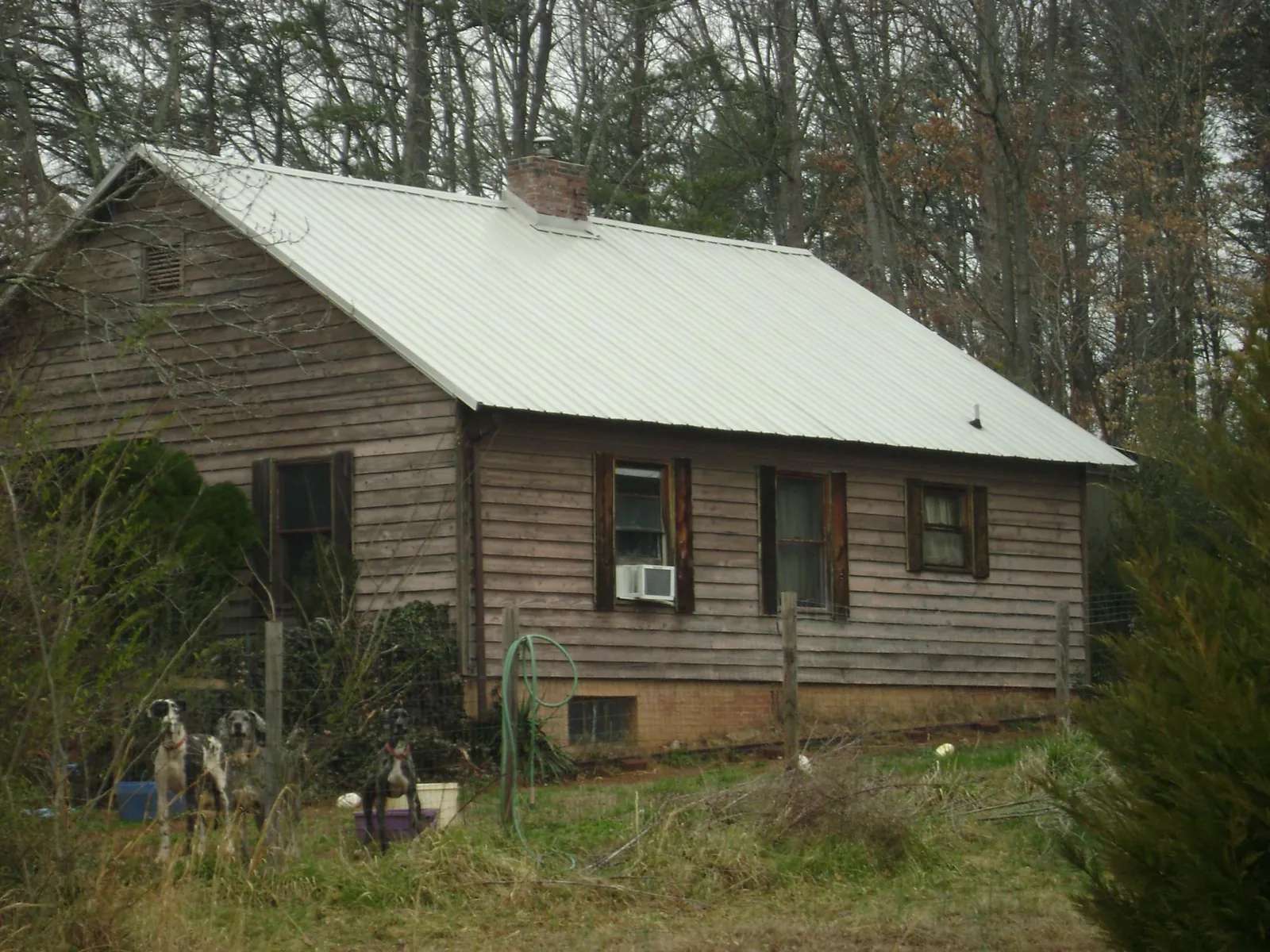 White metal roof on an old wood sided farmhouse, from a Metal Roof Installation job in Blue Mounds